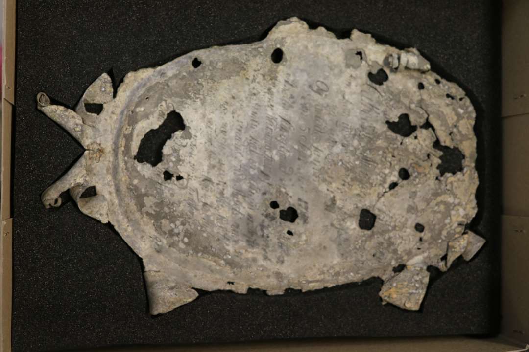 Ligkisteplade (epitafium) af tin, oval form, meget defekt. Af den lange indskrift kan bl.a l�ses:�'Catharina M-------- ' f�dt 'den 7 November 1731' og d�d 'den 5 September 1789'--------.�M�l: 35 x 25 cm.