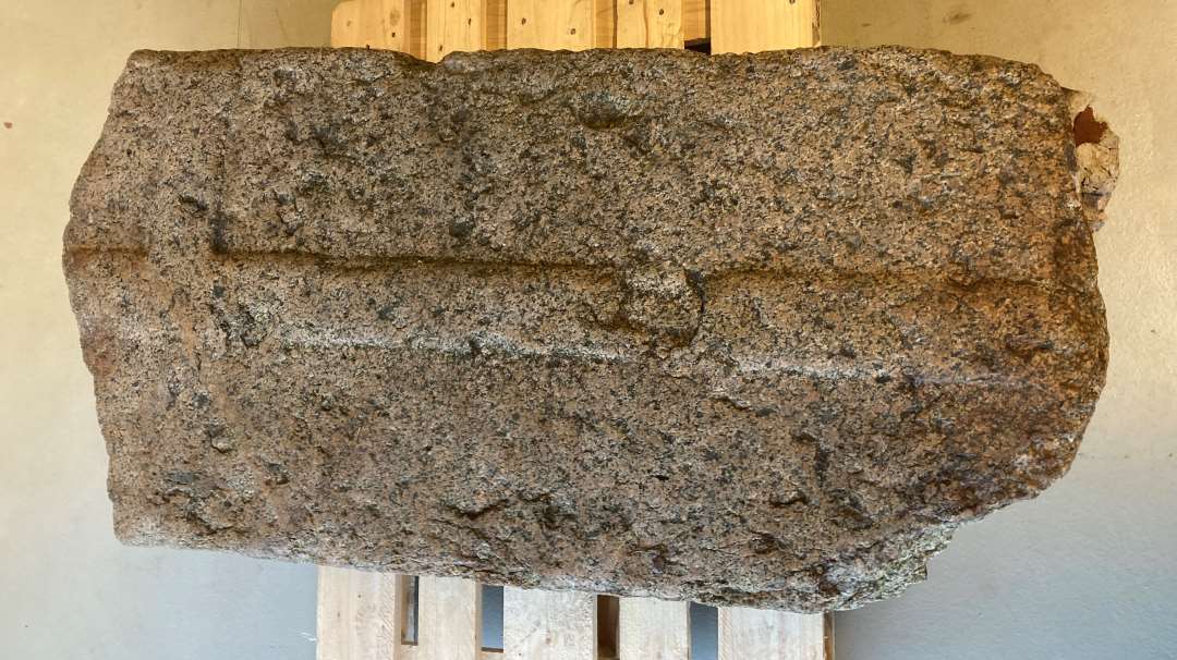 Gravsten af grovkornet, gr� granit med reliefhugget kors, �verste del af stenen mangler. H�jde: 154 cm. Bredde: 79 cm. Tykkelse:  20 cm.  