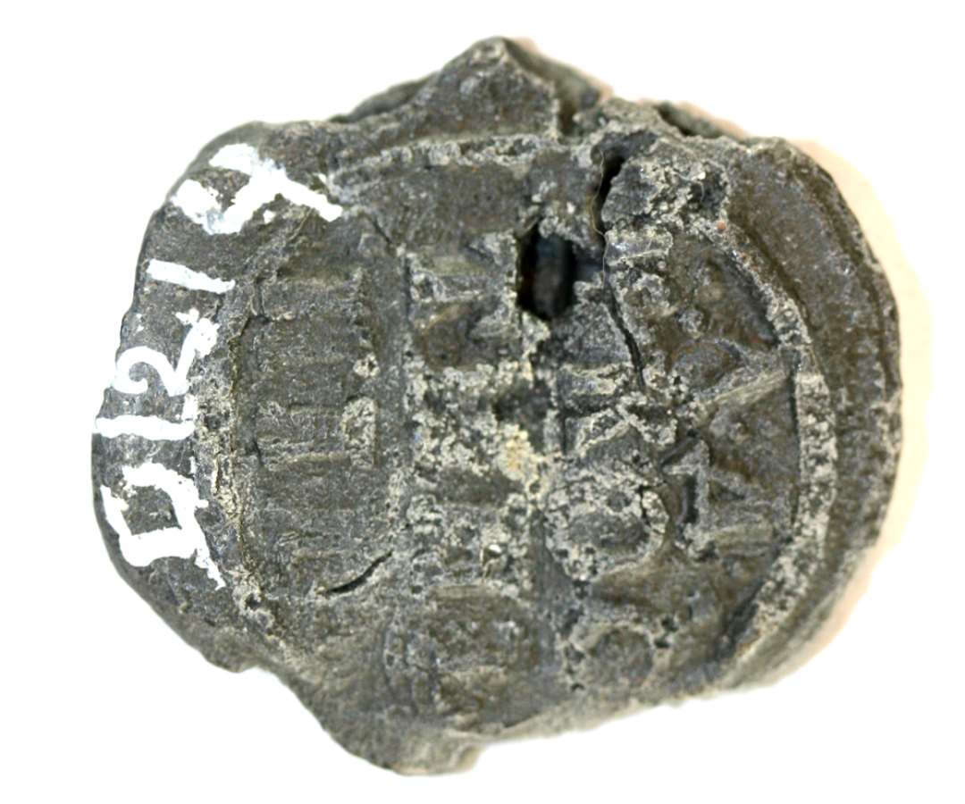 1 blyplombe. Omtrentlig cirkul�r form (diameter: ca. 2,6 cm.). Noget angrebet af pest. Pr�get p� begge sider: p� den ene: '.W.U./LI.W.9?/17(90?)' og p� den anden side formentlig russiske bogstaver i fire r�kker.